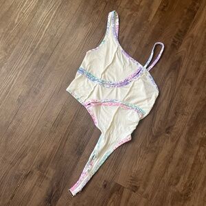 Cream asymmetrical tank top with pink purple and blue tie dye trim details.